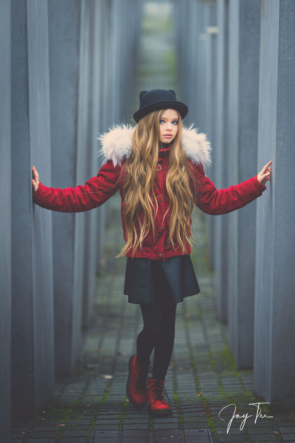 Girl with long blonde hair, red jacket, red shoes and a black hat.